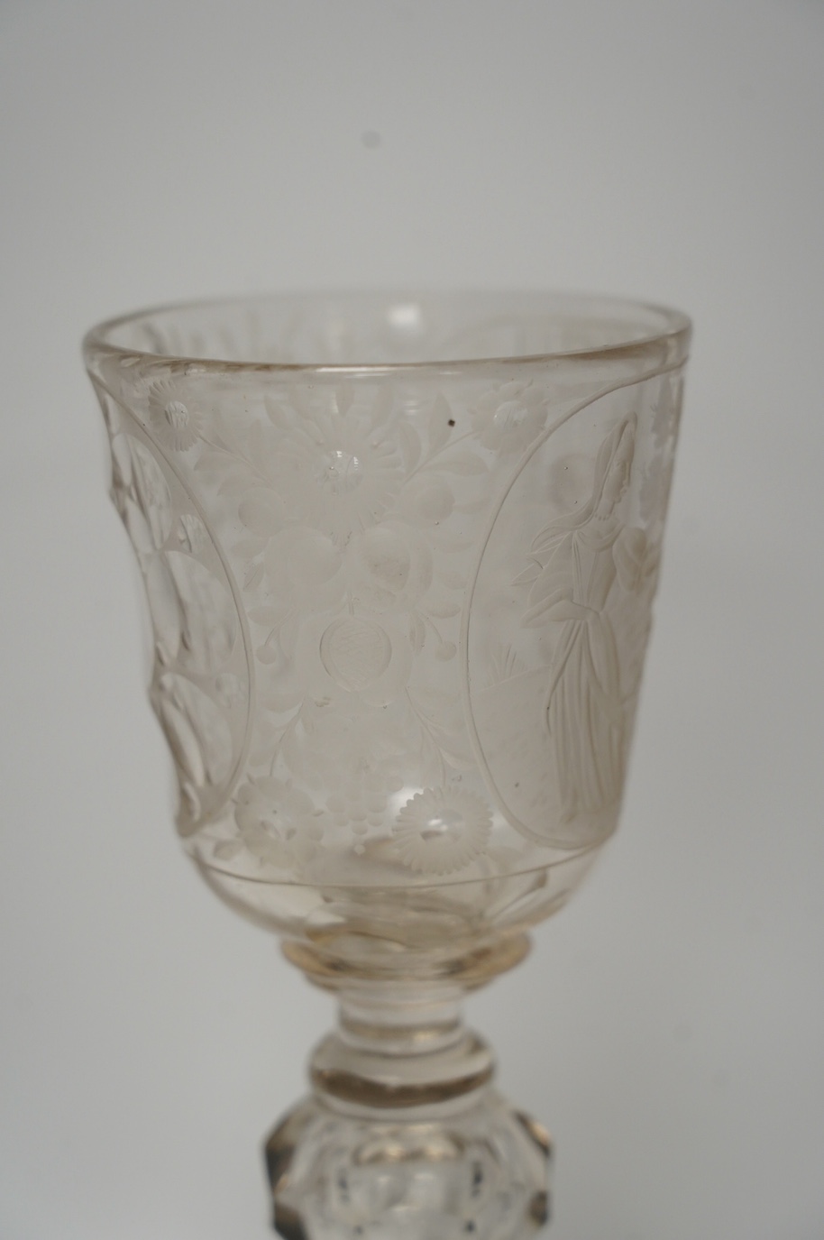 A Victorian engraved tall stemmed wine glass with white metal mounted foot rim, 22cm high. Condition - fair to good